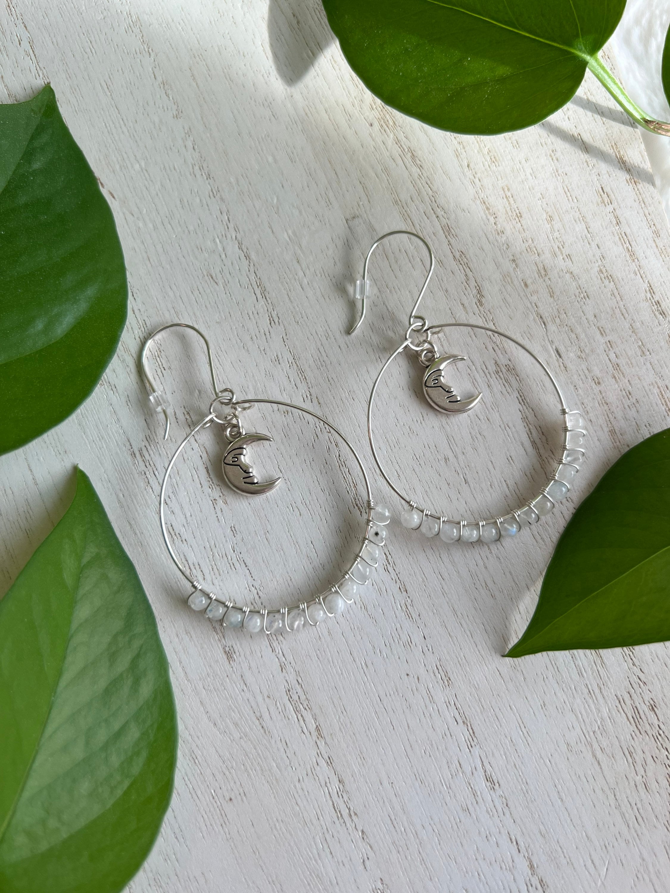 Mystic moonstone briolettes sparkle inside shiny sterling silver hoop earrings on custom ear wires. Mystic moonstone outlet takes on colors near by